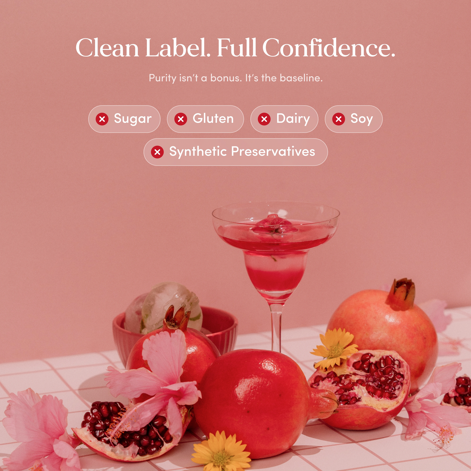 Pink drink in a glass with pomegranates and flowers on a pink background, promoting clean label and confidence.