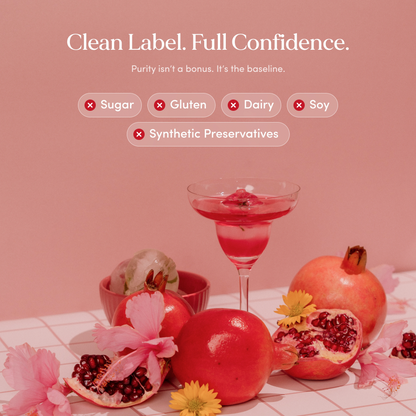 Pink drink in a glass with pomegranates and flowers on a pink background, promoting clean label and confidence.